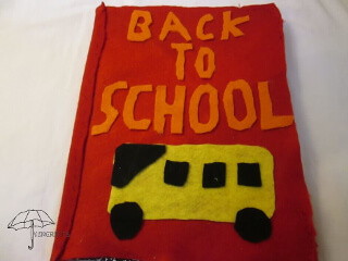red cover with orange words and yellow bus felt notebook cover