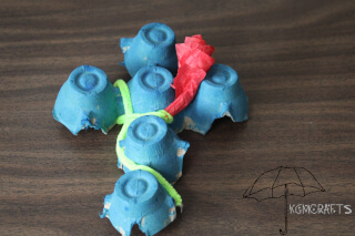 painted blue cross with red tissue rose blue egg carton cross