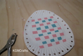 punch holes in the sides of the paper plates