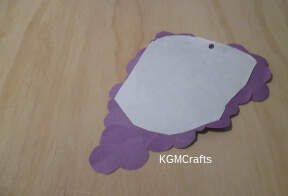 cut off as much of the white paper as you can add a hole near the top of the paper