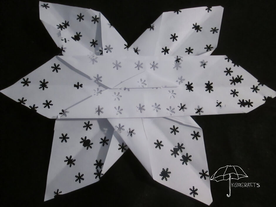 folded paper and hole punched snowflake hole punched showflake