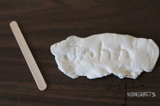 use a craft stick to write John's name John's name writen in clay