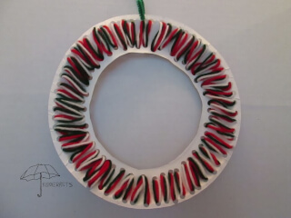 thread yarn through holes to make a wreath lacing wreath