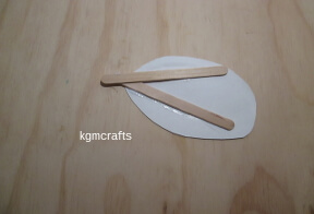glue the oval to the sticks