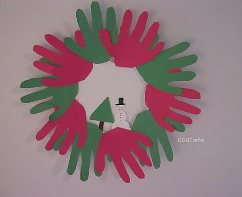 red, green hand prints tree and snowman in center winter hand prints