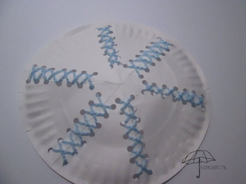 yarn woven through holes on a paper plate yarn lacing snowflake